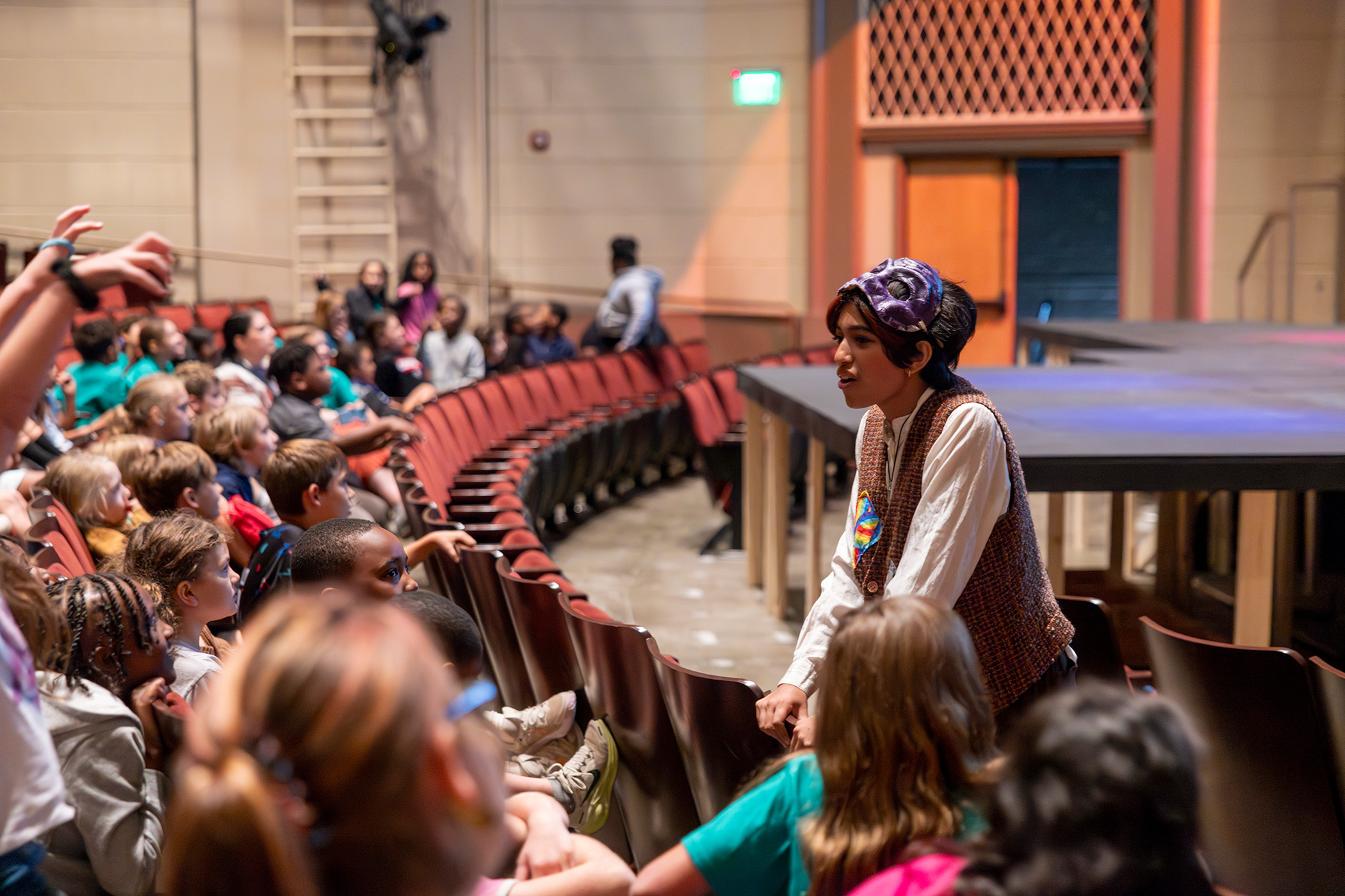 photo of actor speaking to audience members in theatre
