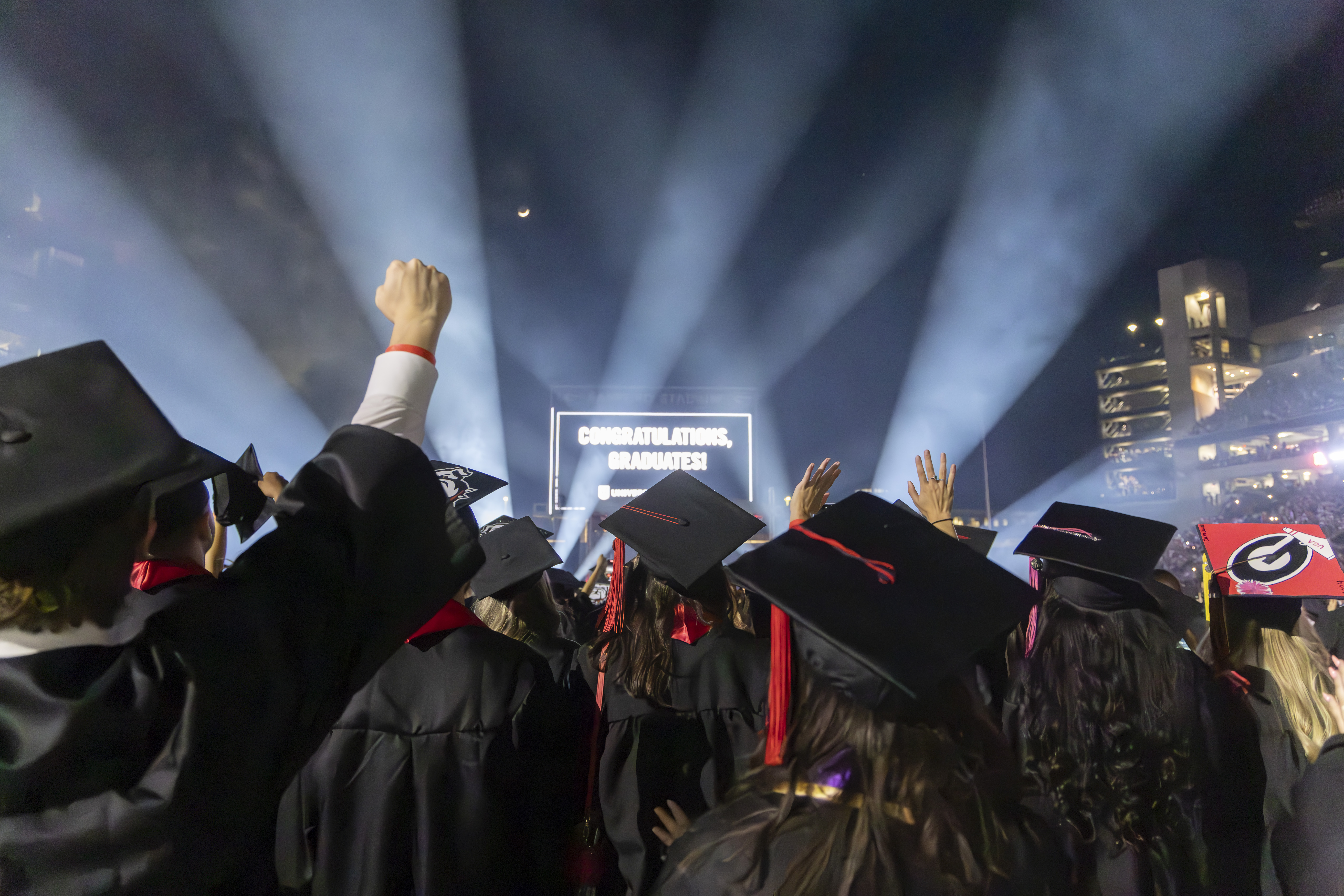 photo of people in caps and gowns, light beams