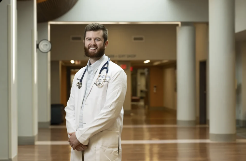 photo of man in white coat, in hallway