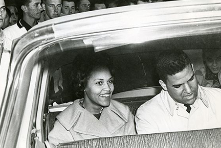 b/w photo of two people in a car, from outside