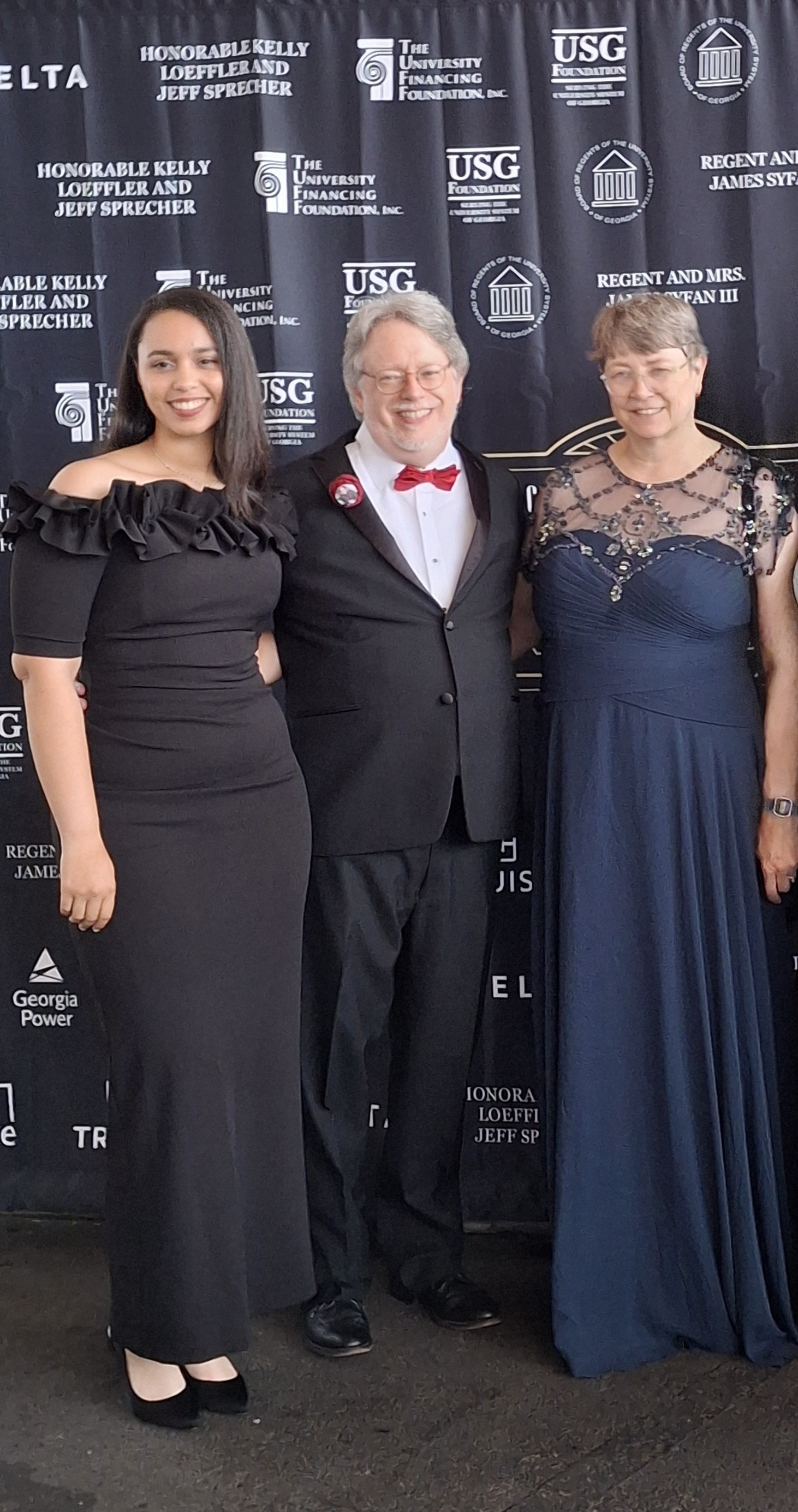 Photo of three people, with graphic backdrop