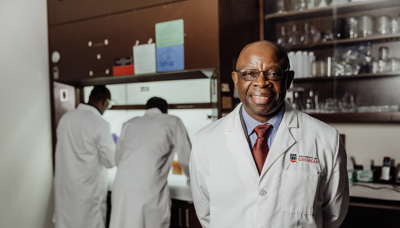 photo of man in lab, with two people in background
