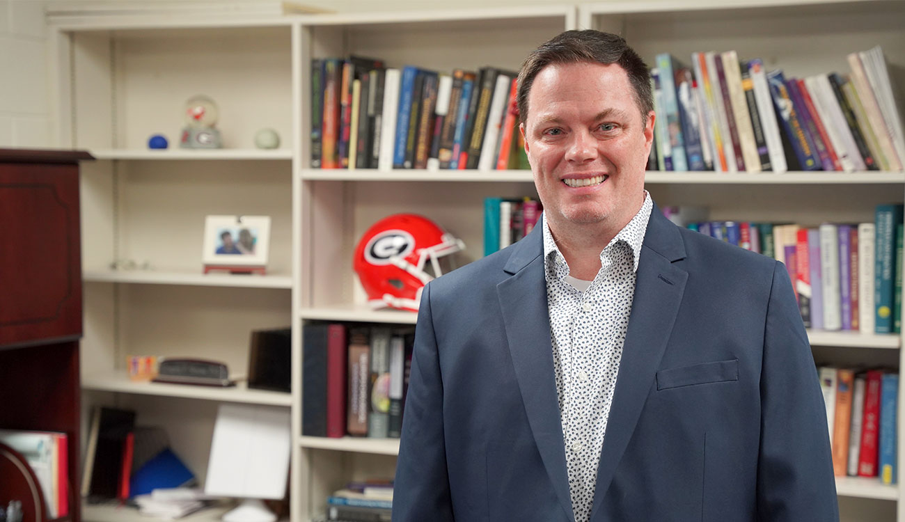 photo of man, bookshelves background