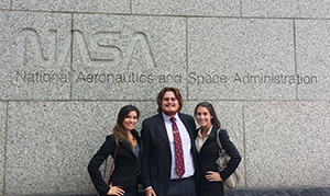 three students in front of NASA sign