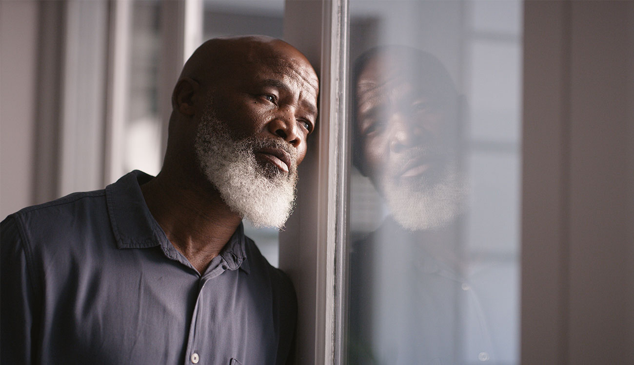 photo of man leaning against window 