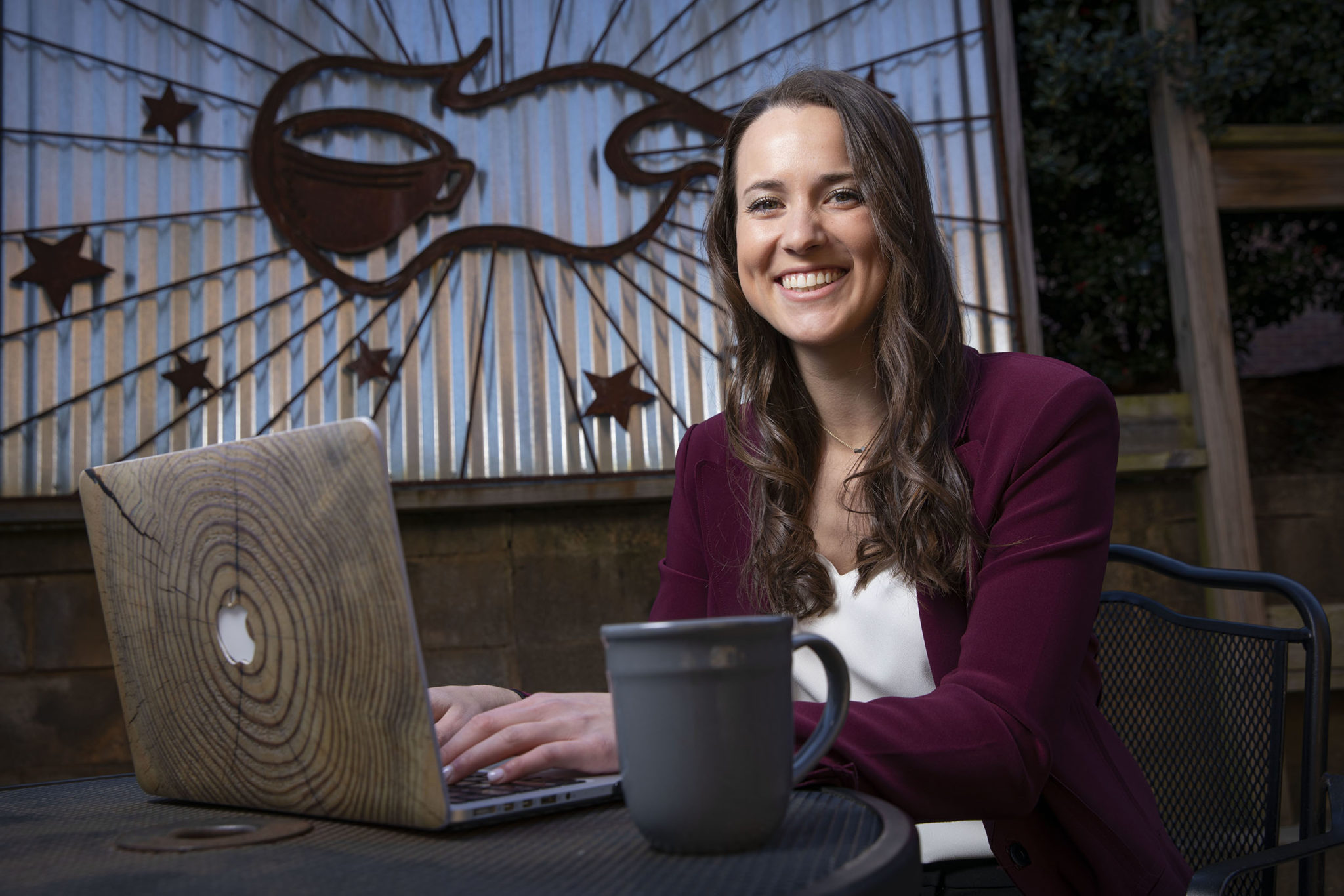 photo of woman with laptop and up of coffee, seated