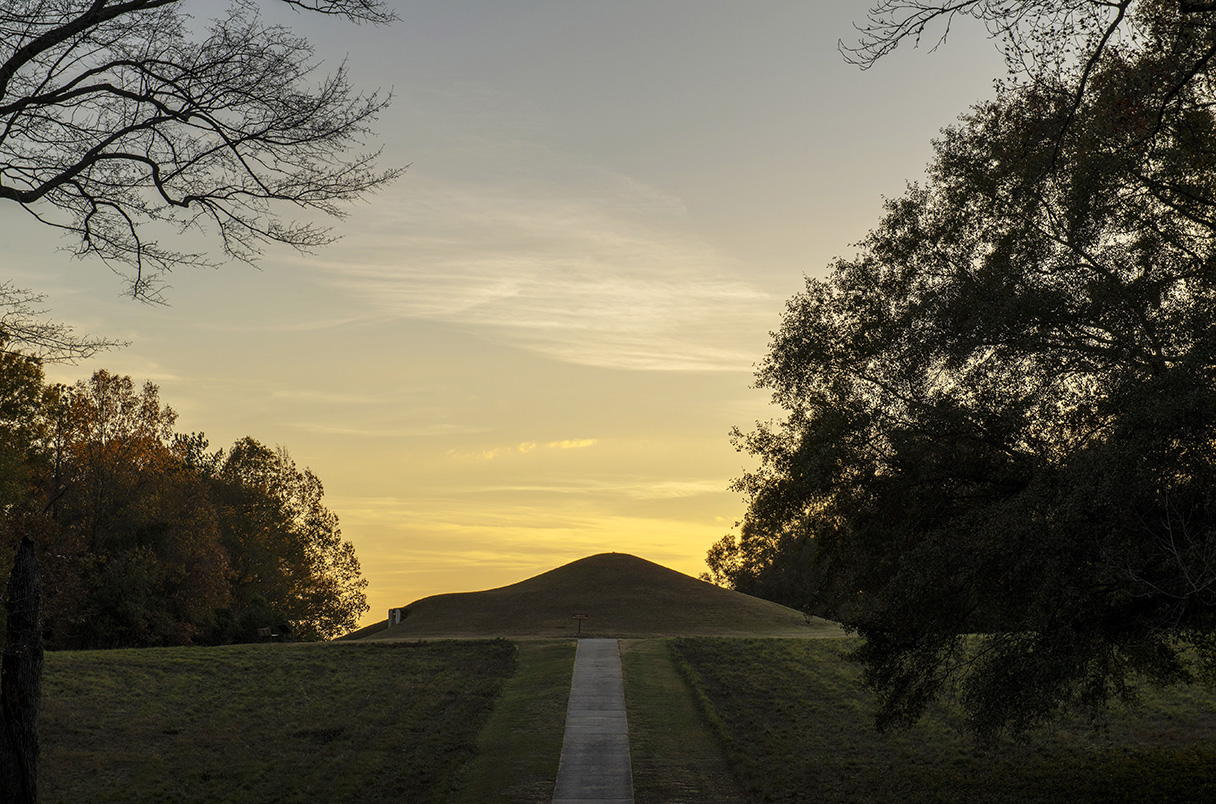 photo of earth mound, covered with grass, twilight