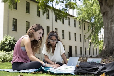 Students reading newspaper outside of Old College