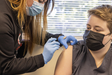 photo of nurse administering vaccination to woman