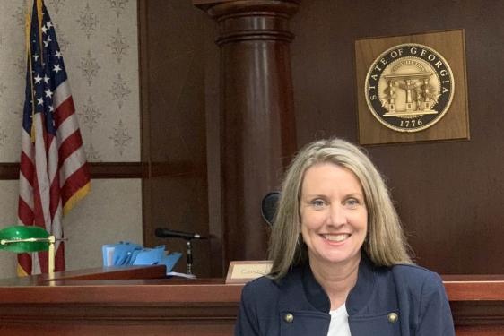 photo of woman, wait flag and state seal in background