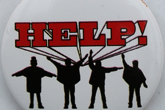 photo of button with the HELP! and four figures